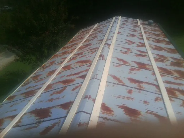 Rusted metal roof panels with new wood purlins before replacement — Storm Damage Roof Repair in Midfield by Roofing Brothers