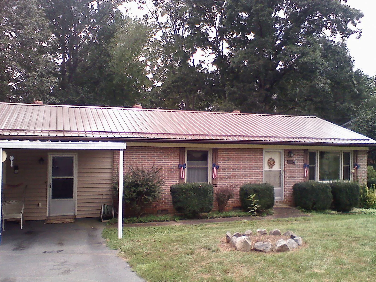 Bronze metal roof and carport on a brick ranch home — Roof Repair work by our crew in Midfield