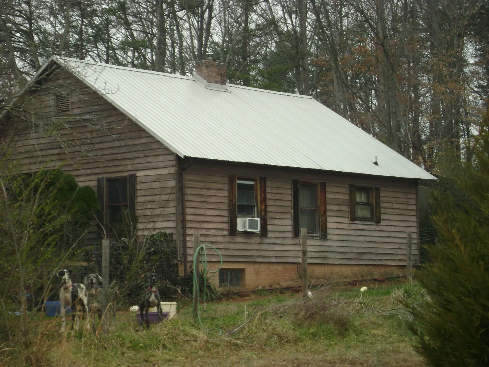 White metal roof on an old wood sided farmhouse, from a Metal Roof Installation job in Midfield
